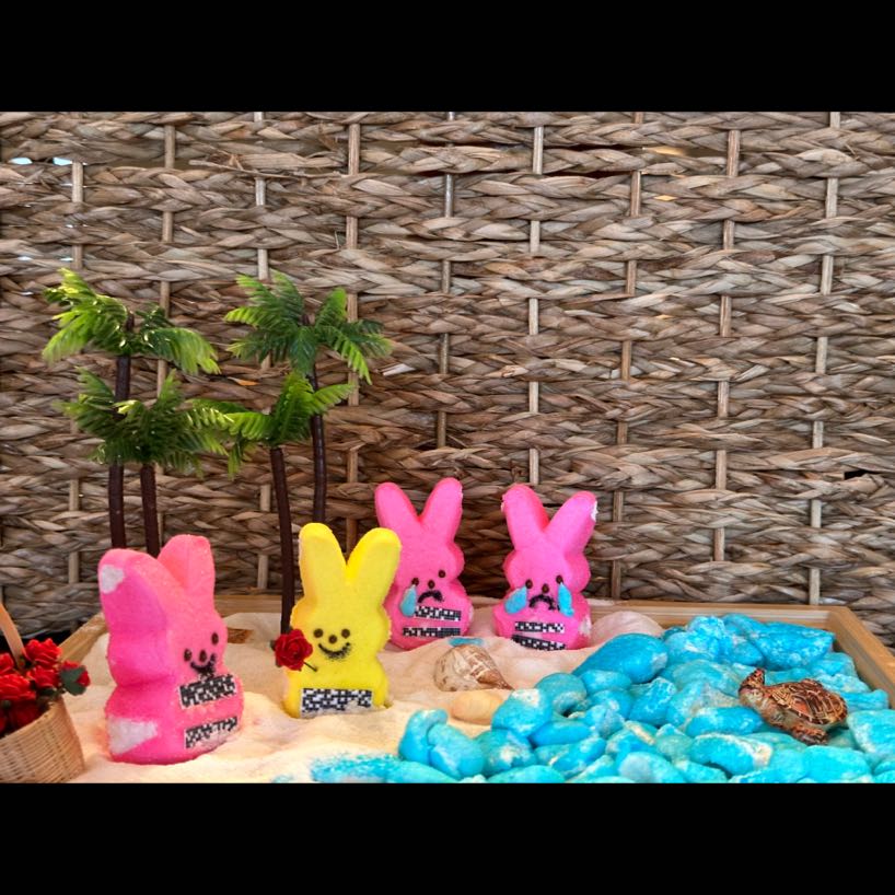 Diorama of rabbit Peeps on a beach with hand-drawn blurs on their private parts