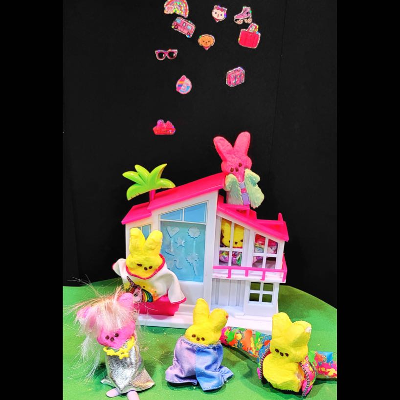 Peeps with Barbie cloting in front of a Barbie house