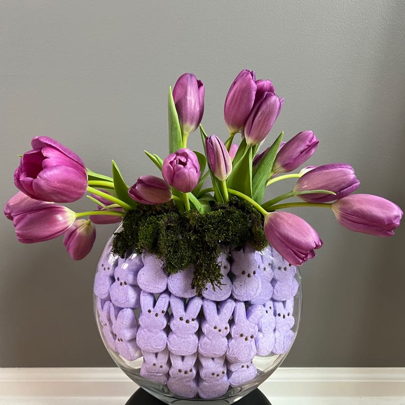 Purple tulips in a vase with purple rabbit Peeps and water